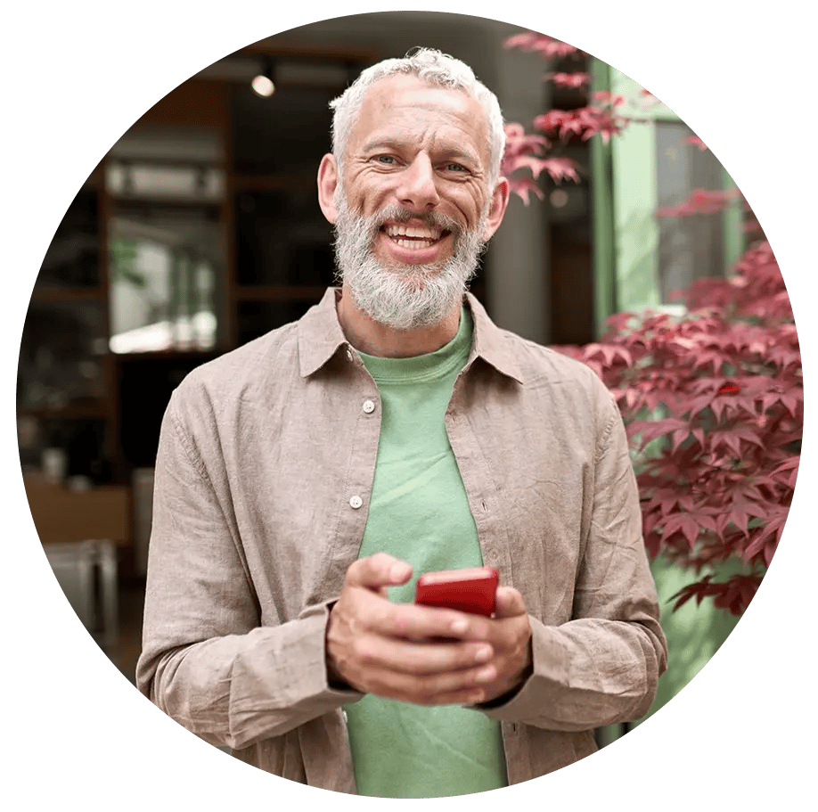 Older man holding a phone in his hand.